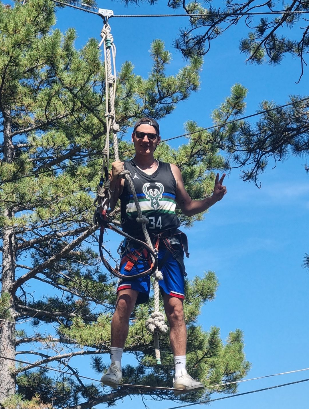 Un Chevalier célèbre sa réussite avec le V de la victoire au cœur de l'atelier du funambule sur le parcours marron. accrobranche Nyons
